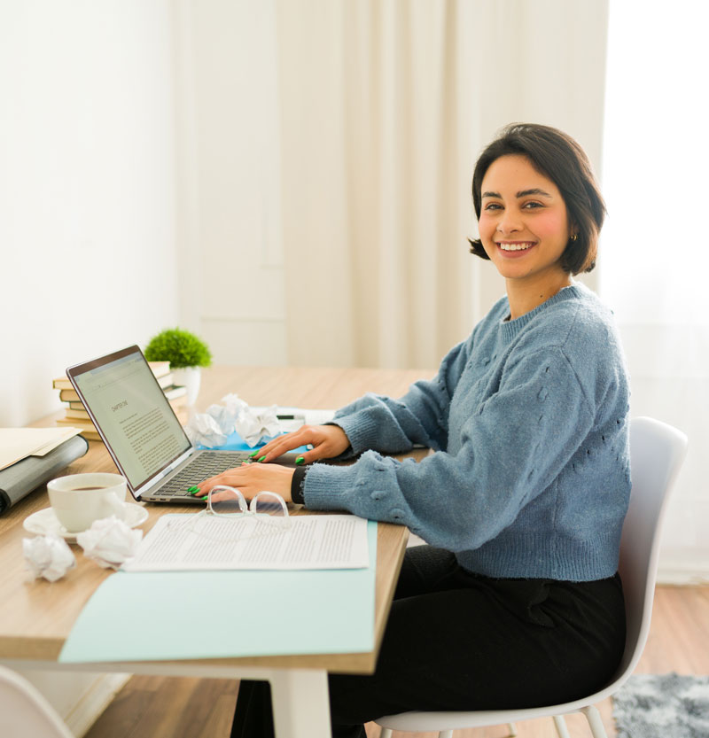 Image of a female writer typing and smiling