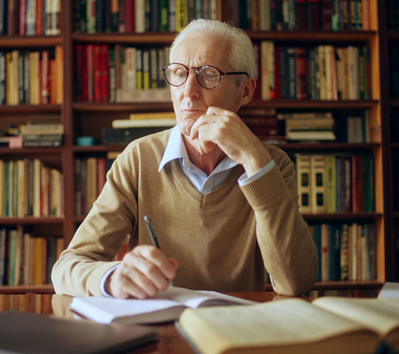 Mature author writing down notes for next book