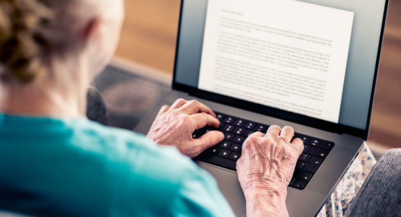 Senior women typing a manuscript on a laptop